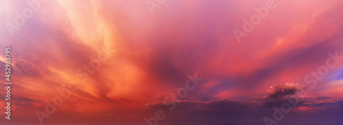 Dramatic sky background with orange and purple clouds at sunset.