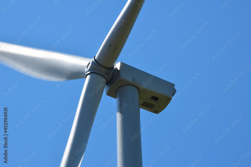 Huge wind generator close up against the background of a bright clear blue sky Huge wind generator close up against the background of a bright clear blue sky