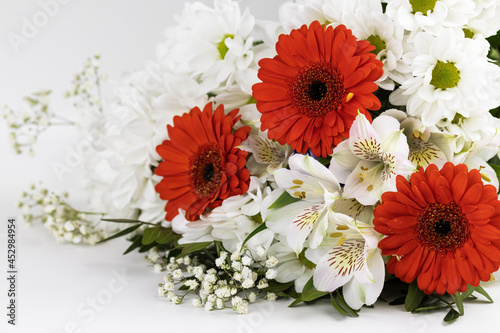 A bouquet of red gerberas, white lilies and daisies, isolated on a white background.