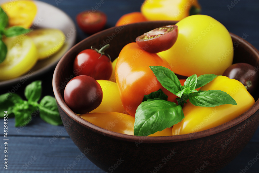 Ripe tomatoes of different varieties, spices, and sweet peppers on a wooden background Ripe tomatoes of different varieties, spices, and sweet peppers on a wooden background