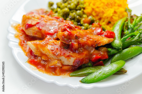 Chicken breast in a tomato and red pepper sauce with spiced long grain rice and crushed minted peas