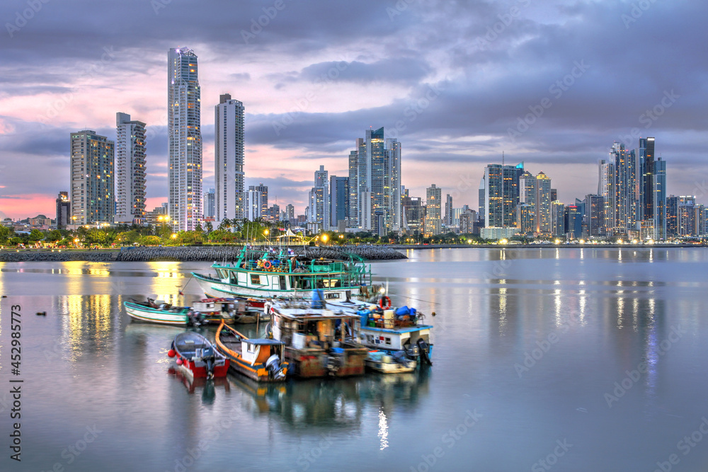 Panama City skyline with local colorful fishing boats against the futuristic highrise background.