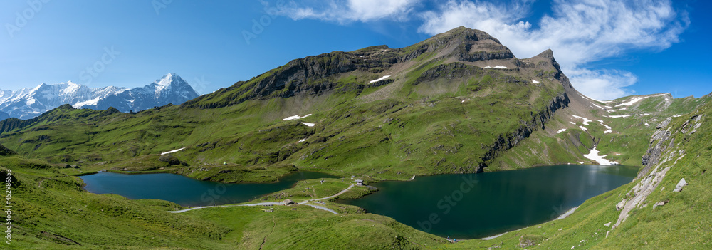 Fototapeta premium panorama sur deux lacs de montagne au milieu des prairies des alpes