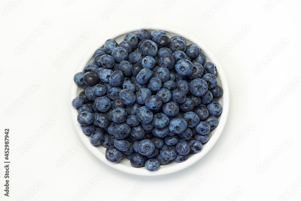 Fresh blueberries in white plate on white background, top view Fresh blueberries in white plate on white background, top view