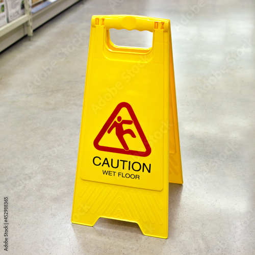 Wet floor caution sign. Yellow sign that alerts for wet floor. Caution slippery surface sign.