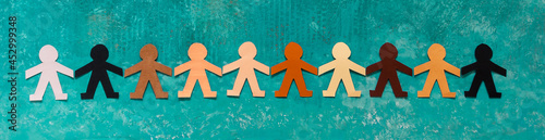 Banner of a multi-ethnic paper dolls chain holding hands against racism photo