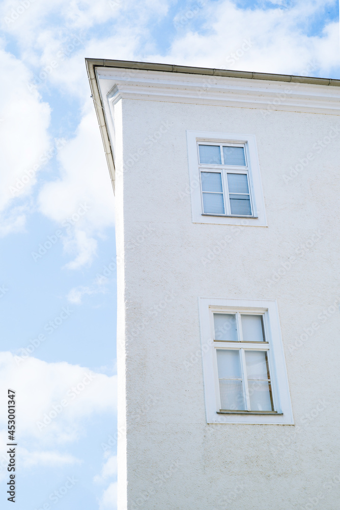 Hausfassade mit Fenstern unter blauem Himmel Hausfassade mit Fenstern unter blauem Himmel
