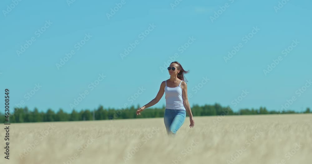 Happy and beautiful girl walks across the field and smiles. Girl in sunglasses walks in a rye field, happy moments. 4k, ProRes Happy and beautiful girl walks across the field and smiles. Girl in sunglasses walks in a rye field, happy moments. 4k, ProRes