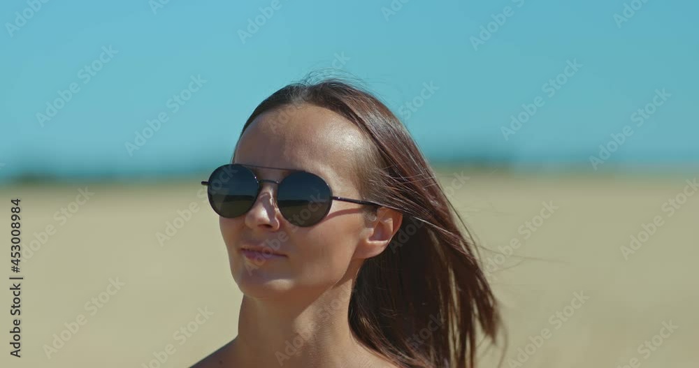 Portrait, a young woman in sunglasses is walking, she is happy. Beautiful landscape, blue sky. 4k, ProRes Portrait, a young woman in sunglasses is walking, she is happy. Beautiful landscape, blue sky. 4k, ProRes