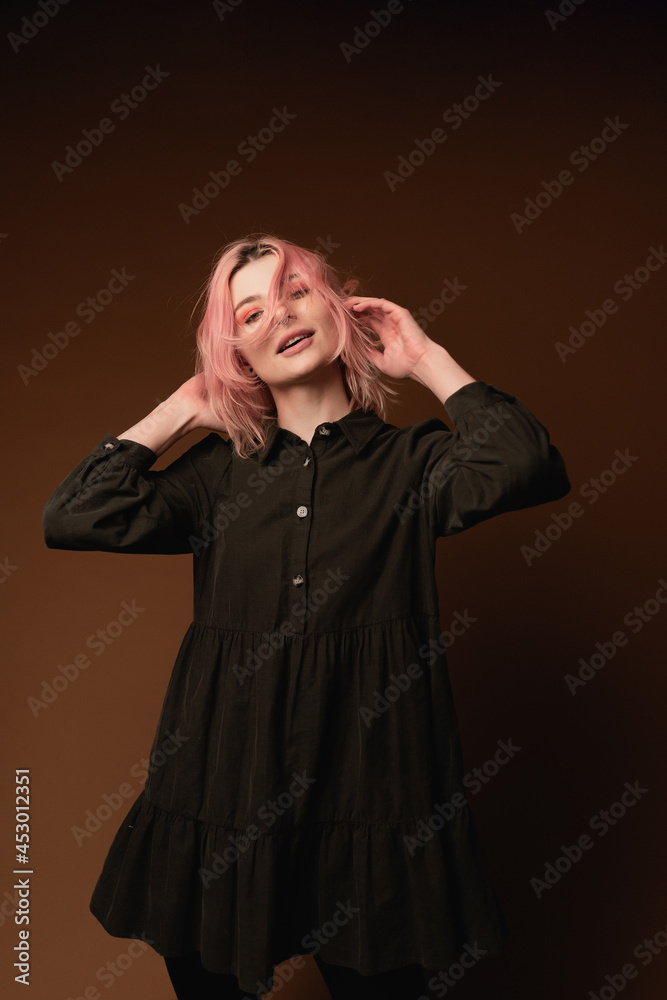Young woman girl with pink hair at brown wall background studio portrait. People sincere emotions lifestyle concept Young woman girl with pink hair at brown wall background studio portrait. People sincere emotions lifestyle concept