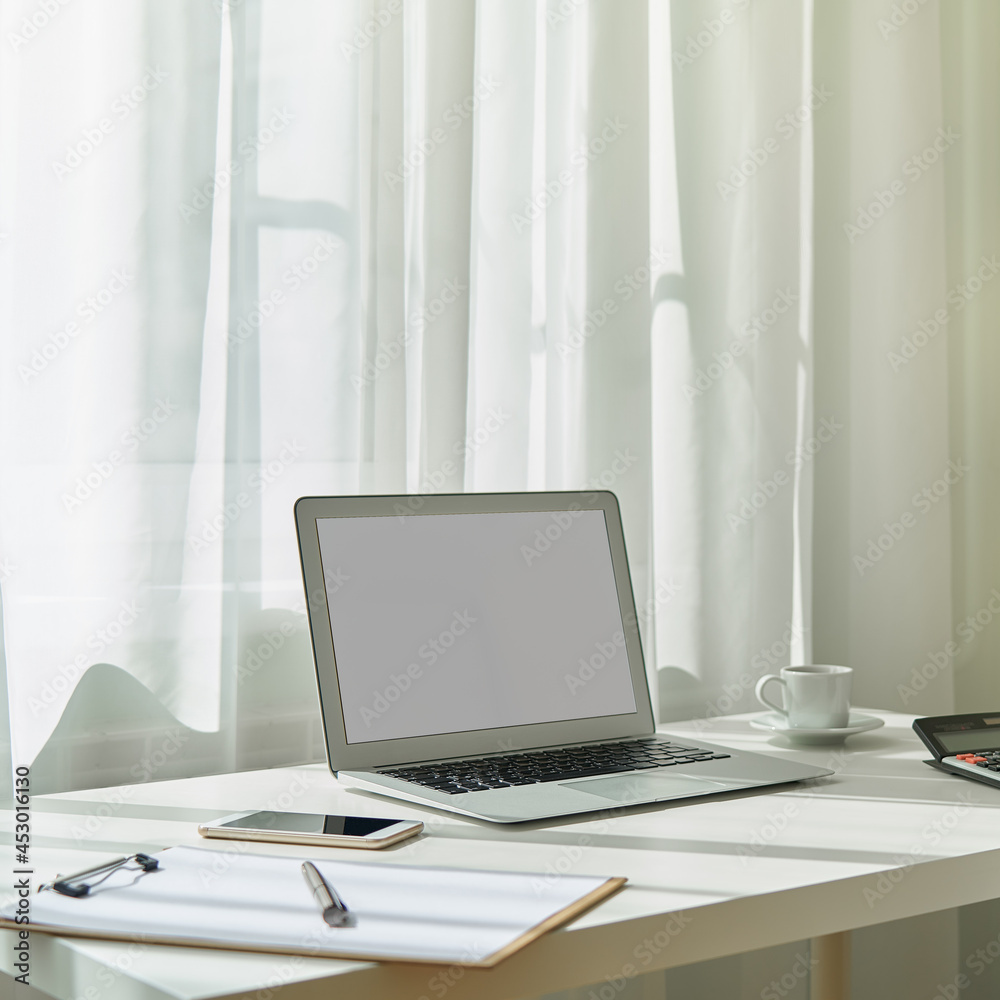 Obraz premium Freelance desk with laptop, smartphone. Distance education, online learning. Quarantine teleworking, online lectures. Concept of digital nomads, home office. Natural light, copy space, blank screen