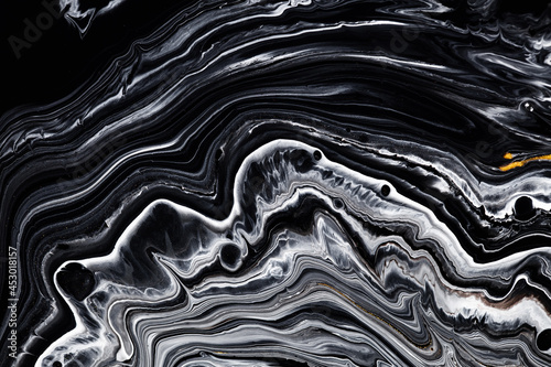 Fluid art texture. Abstract background with iridescent paint effect. Liquid acrylic picture with flows and splashes. Mixed paints for baner or wallpaper. Golden, black and gray overflowing colors.