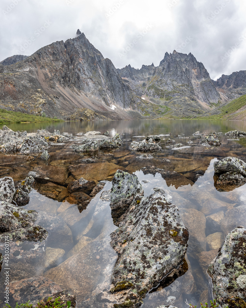 Landscape of Grizzly Lake in northern Canada, Yukon, sub arctic area with pristine water below massive mountain peaks. Landscape of Grizzly Lake in northern Canada, Yukon, sub arctic area with pristine water below massive mountain peaks.