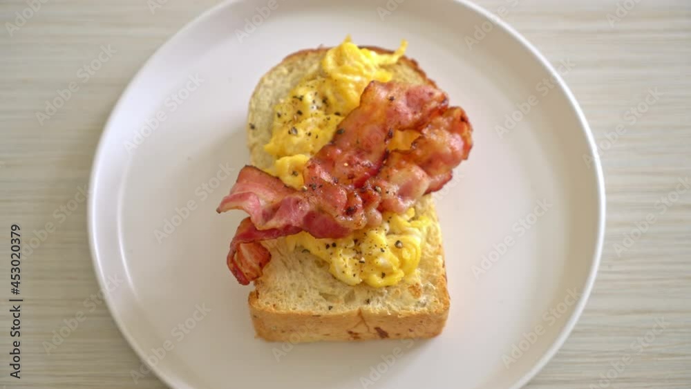 bread toast with scramble egg and bacon on white plate