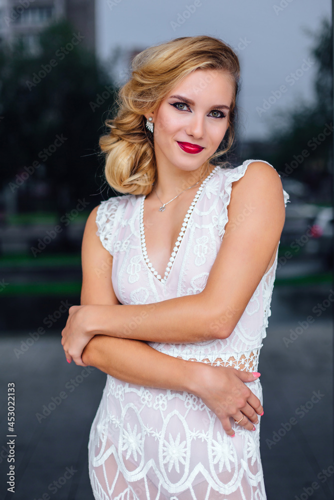 Beautiful blond bride in white wedding dress standing near mirror window outdoors. Beautiful blond bride in white wedding dress standing near mirror window outdoors.