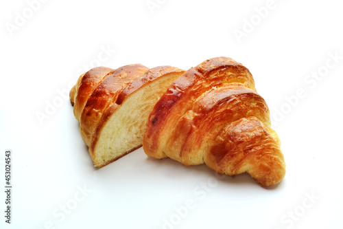 Croissant split into two parts on a white background
