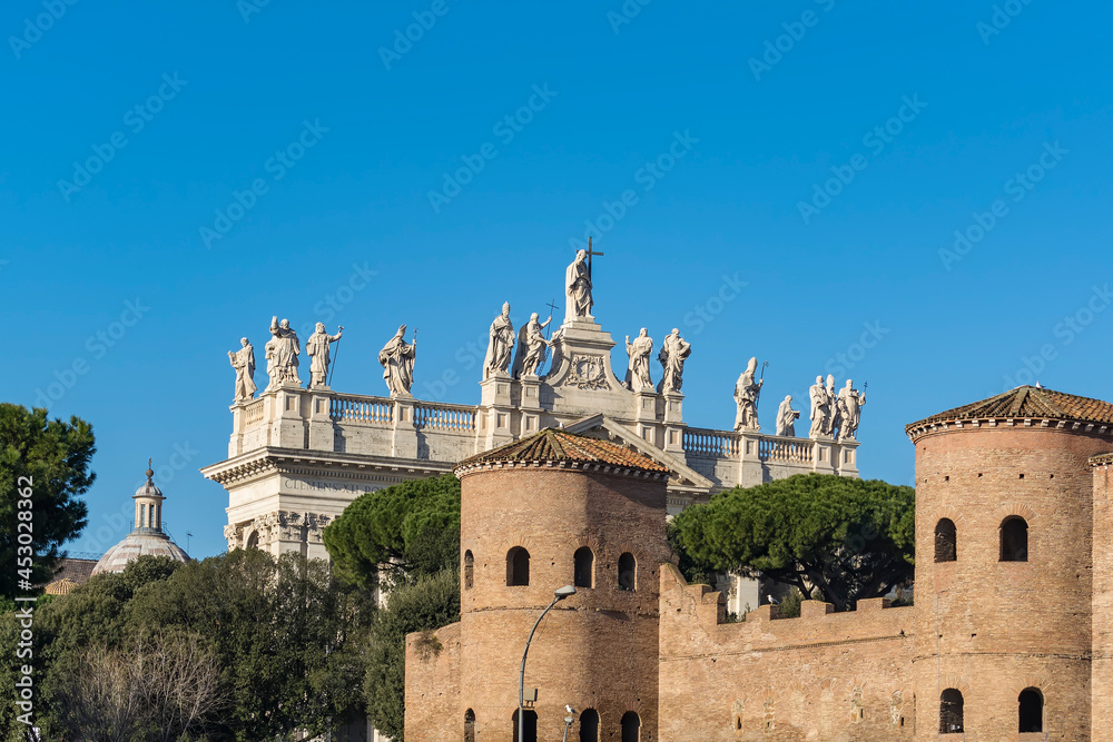 A view of the Papal Archbasilica of St. John in Lateran and towers of the Porta Asinaria in Rome, Italy