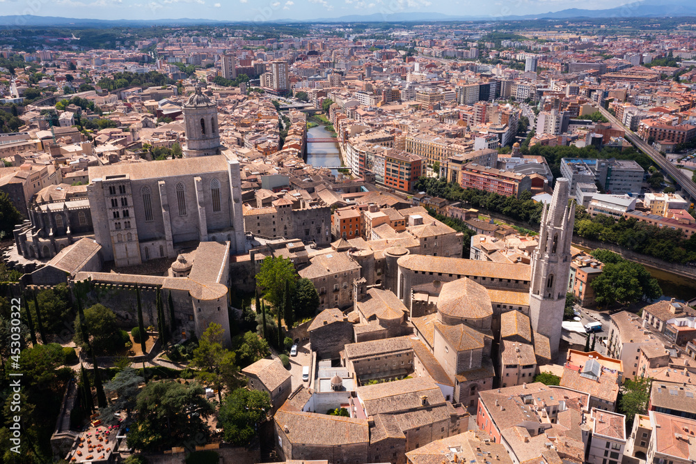Aerial view of main landmarks of Girona - Saint Mary Cathedral and Collegiate Church of Sant Feliu on Onyar river on sunny summer day, Spain