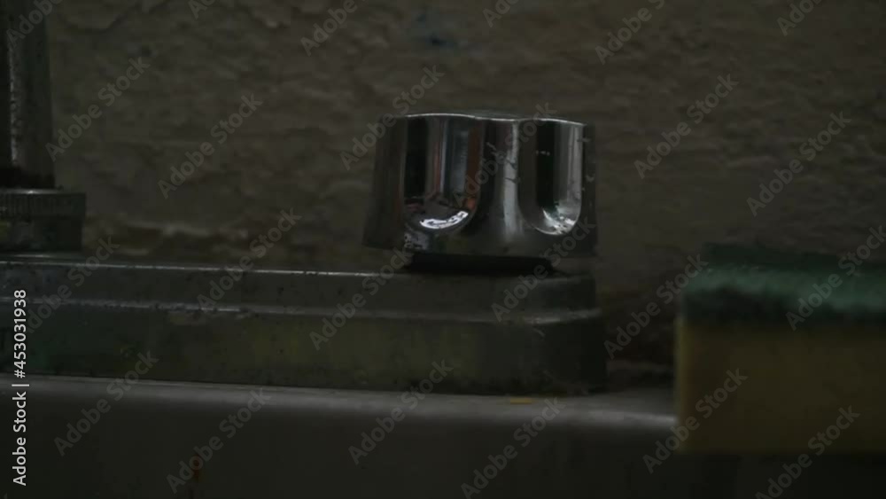 Opening an old faucet with a hand Opening an old faucet with a hand