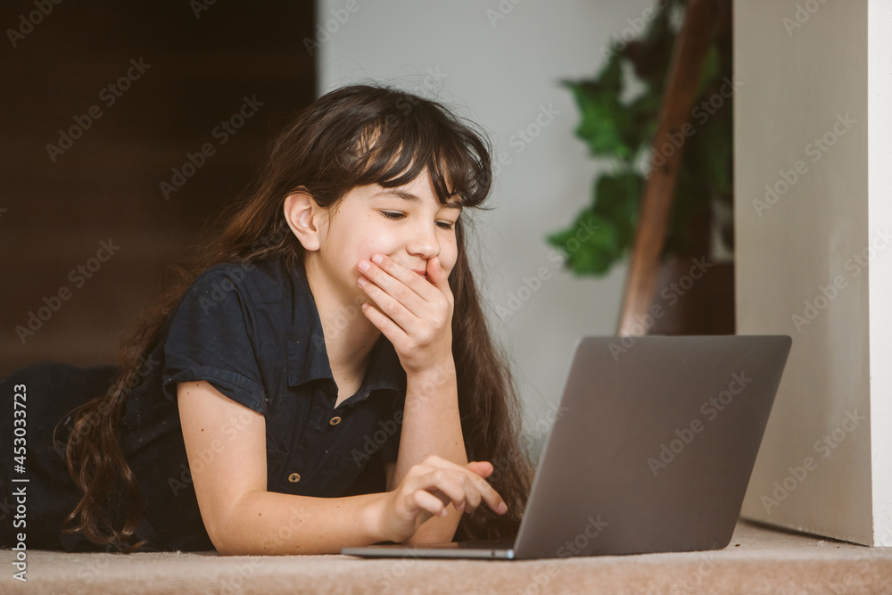 portrait of adorable child girl doing on-line learning using laptop at home, home schooling, online education portrait of adorable child girl doing on-line learning using laptop at home, home schooling, online education
