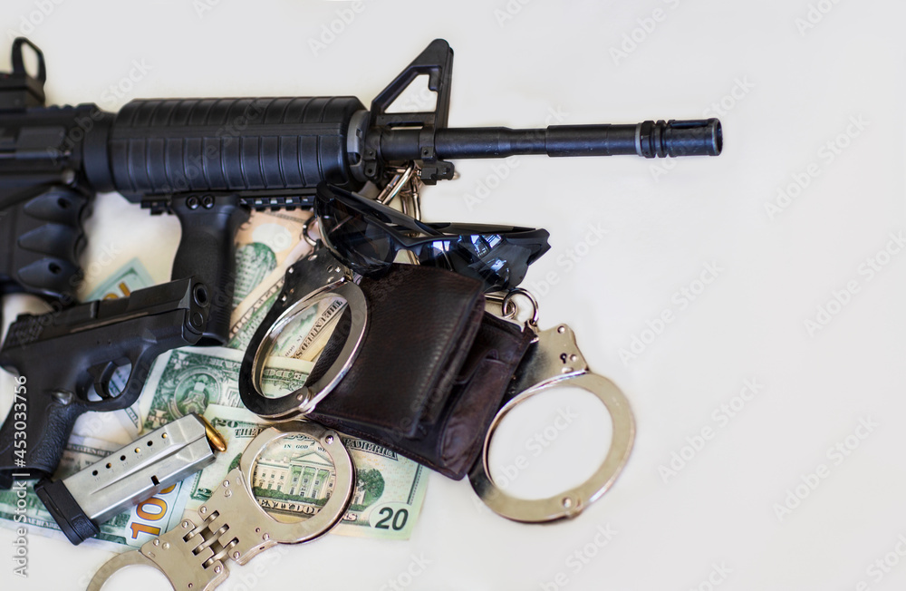 Obraz premium Modern automatic rifle, Pistol, gun and bullets 9mm ammunition, handcuffs on American dollars banknotes. Criminal money and punishment, Copy space. Legendary U.S. Army Handgun with assault rifle.