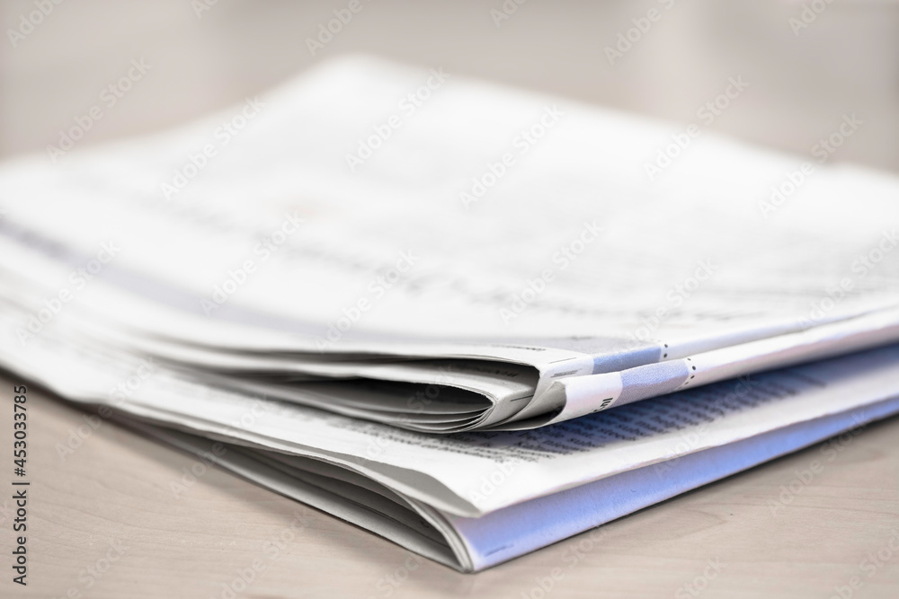Newspaper on a wooden table, with shallow depth of field Newspaper on a wooden table, with shallow depth of field