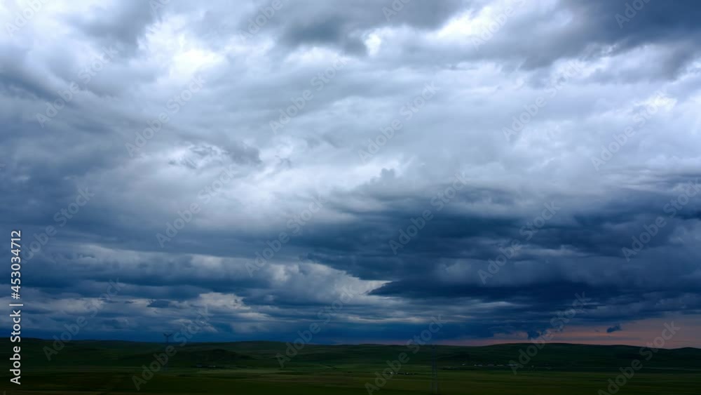 Time-lapse photography of dark clouds billowing in the sky above the grass Time-lapse photography of dark clouds billowing in the sky above the grass