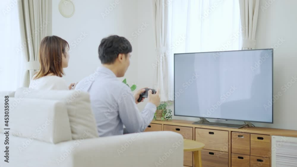 テレビゲームで対戦して勝つ彼氏と負ける彼女 Stock ビデオ | Adobe Stock