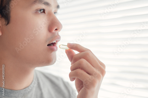 A man is eating a pill.