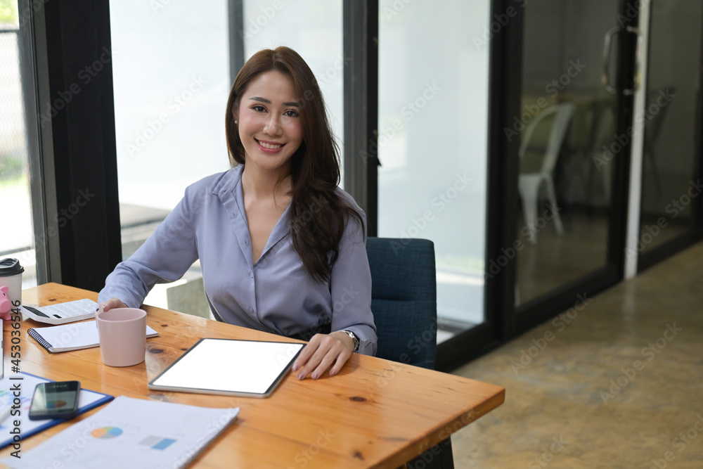 Successful business sitting at modern workplace and smiling to camera. Successful business sitting at modern workplace and smiling to camera.