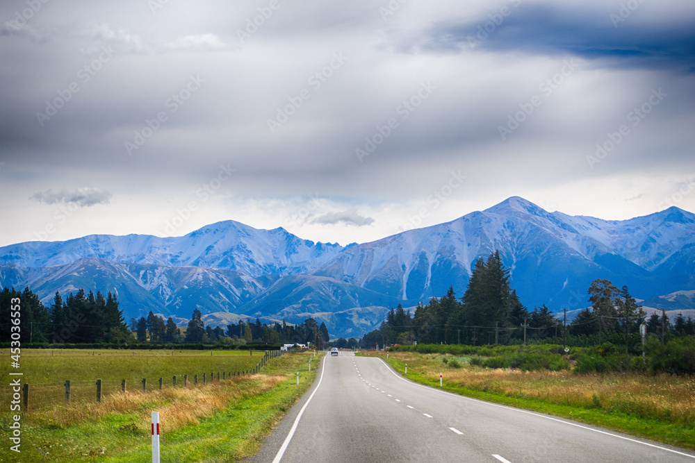 Rural Scene of Asphalt Road with Meadow and Mountain Range, South Island, New Zealand