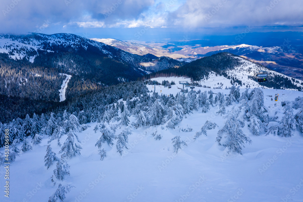 Obraz premium Panorama of the ski resort Kopaonik in Serbia. Kopaonik National Park, winter landscape in the mountains, coniferous forest covered with snow