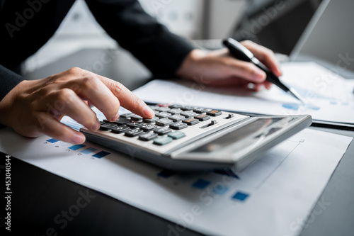 Close up of businesswomen or accountant using calculator calculate while working analytic business report on the workplace  Planning financial and accounting concept.