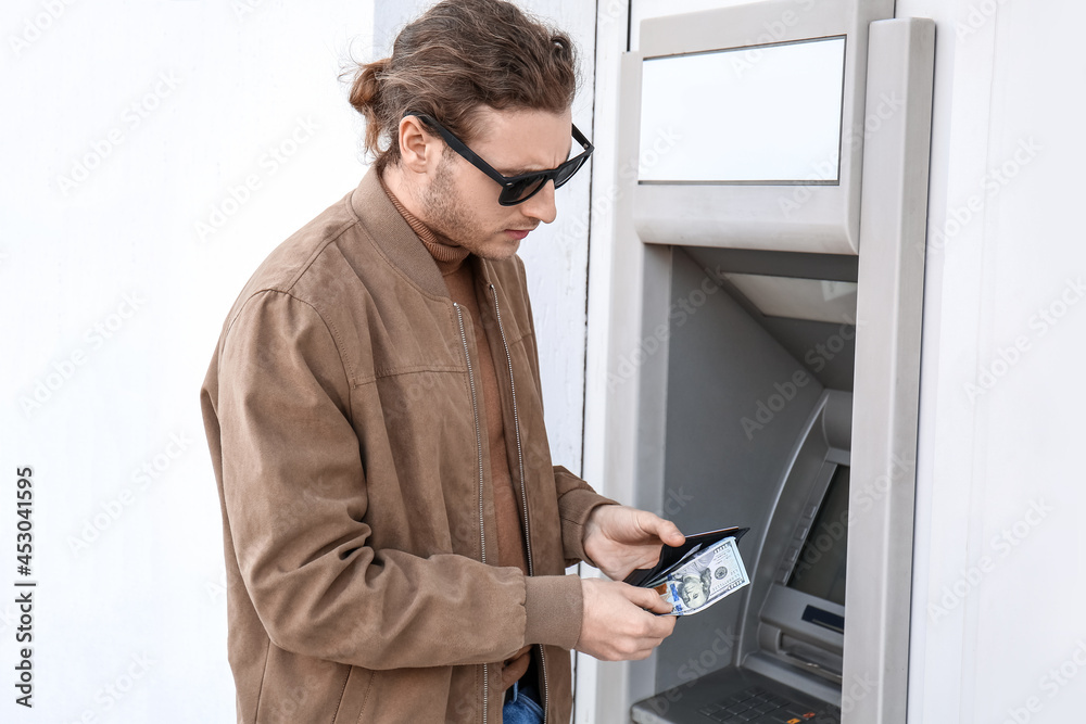 Man withdrawing money from ATM Man withdrawing money from ATM