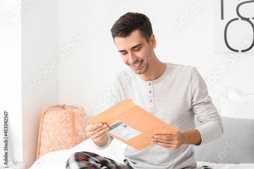 Young man with letter in be...