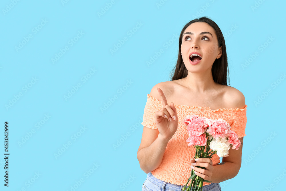 Young woman with carnation flowers pointing at something on color background Young woman with carnation flowers pointing at something on color background