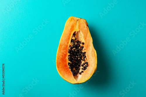 Summer composition. Tropical papaya fruits cut in half lie on a blue background. Summer concept. Flat lay, top view, copy space