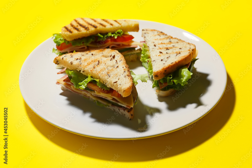 Plate with tasty sandwiches on color background, closeup Plate with tasty sandwiches on color background, closeup