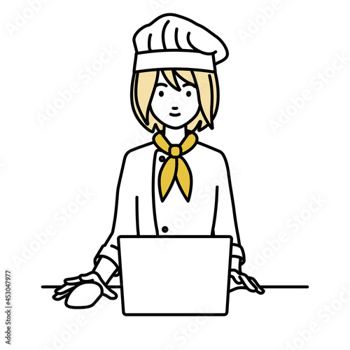 デスクで座ってPCを使っている調理師の女性