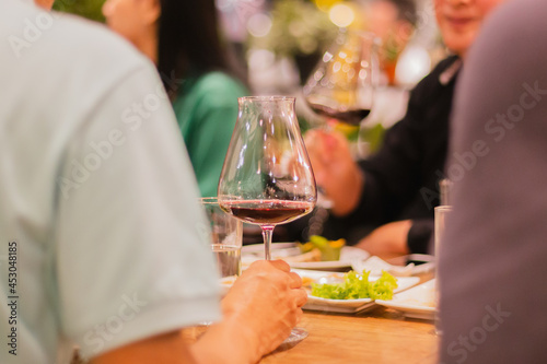 Selected focus of glasses of red wine on table at meeting dinner in indoor.