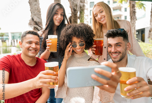 Group of friends posing for a selfie with pints of beer