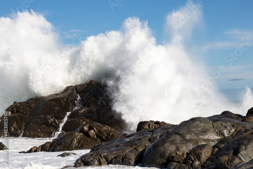 Huge wave crashes on rocks