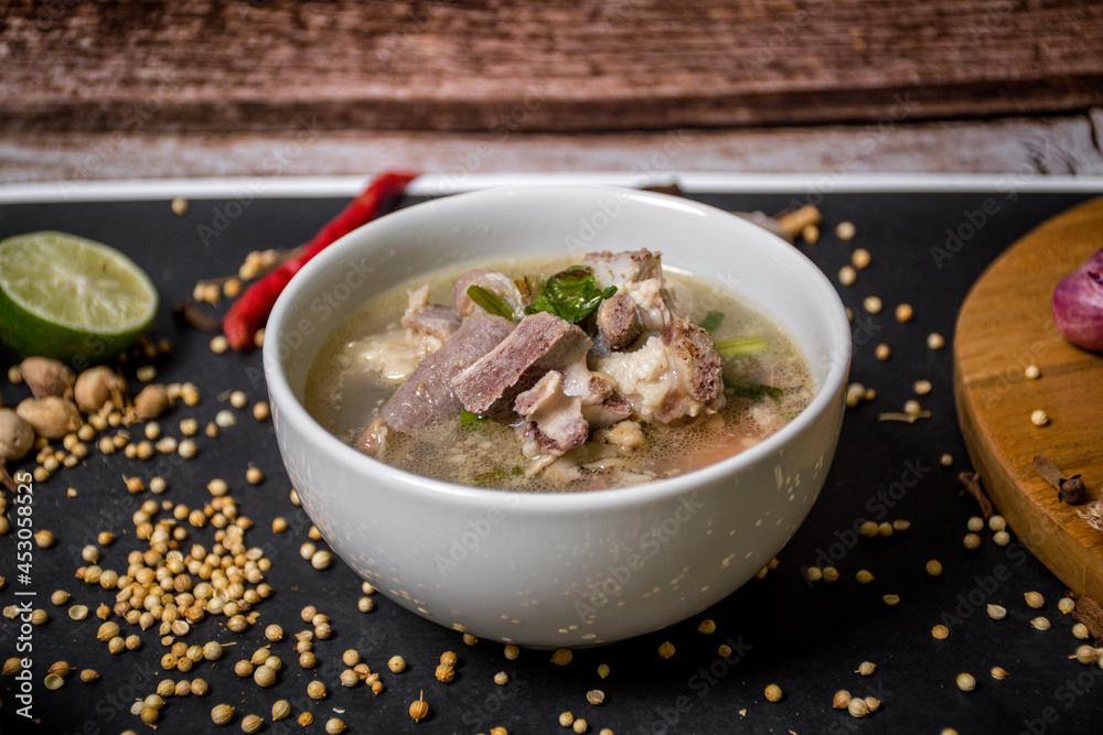 Indonesian goat soup with tomatoes, celery, green onions, ginger, hazelnut and lime leaves Indonesian goat soup with tomatoes, celery, green onions, ginger, hazelnut and lime leaves