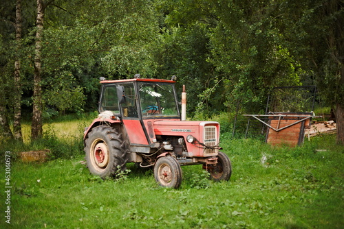Old red agricultural tractor outdoors photo