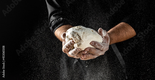 Male hands making dough for pizza. Beautiful and strong men's hands knead the dough make bread, pasta or pizza