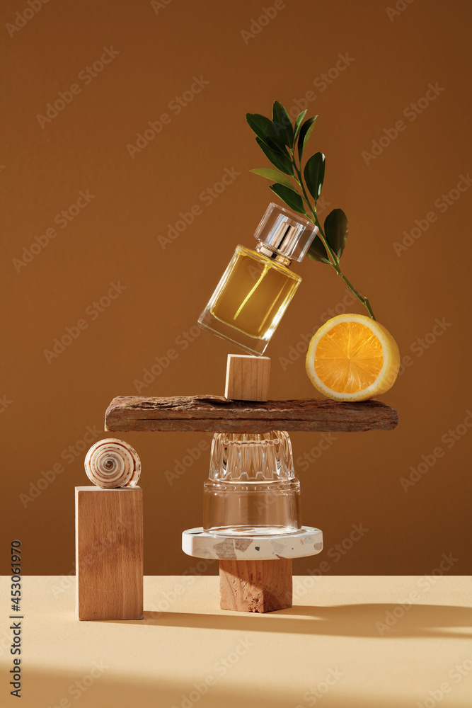 Mockup geometric shape stone podium with glass perfume bottle. Stone, wood shape with lemon yellow ingredients shades over concept background. direct angle . Can use as perfume and cosmetics mock up - obrazy, fototapety, plakaty 