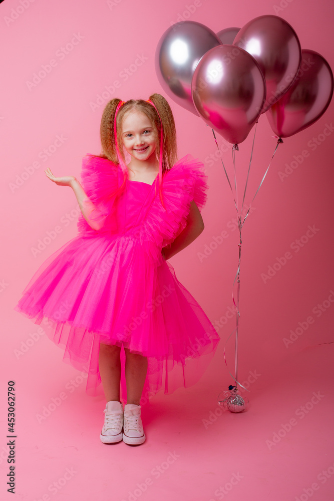little girl on a pink background holding balloons, celebrating her birthday little girl on a pink background holding balloons, celebrating her birthday