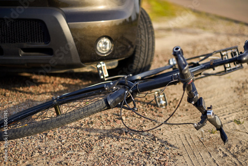 Photo of car and bicycle on the road.