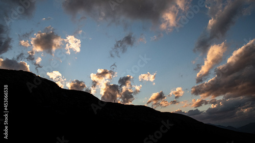 ciel pendant un coucher de soleil avec une femme en silhoutette dans les montagnes du parc naturel regional de l'Ubaye dans les alpes francaises. photo