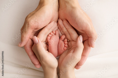 the legs of the child in the arms of our mother and father. feet of a newborn baby. little baby legs.